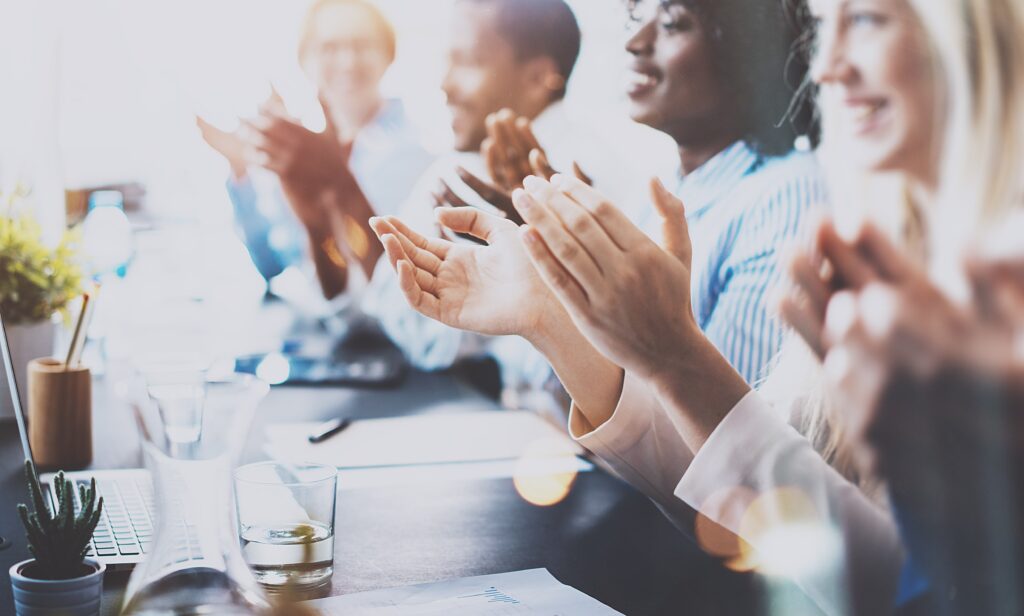 people in boardroom clapping