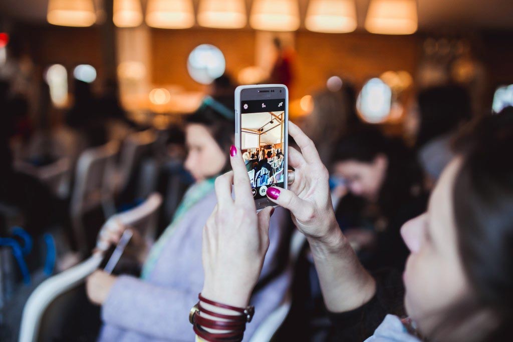 woman taking photo with phone
