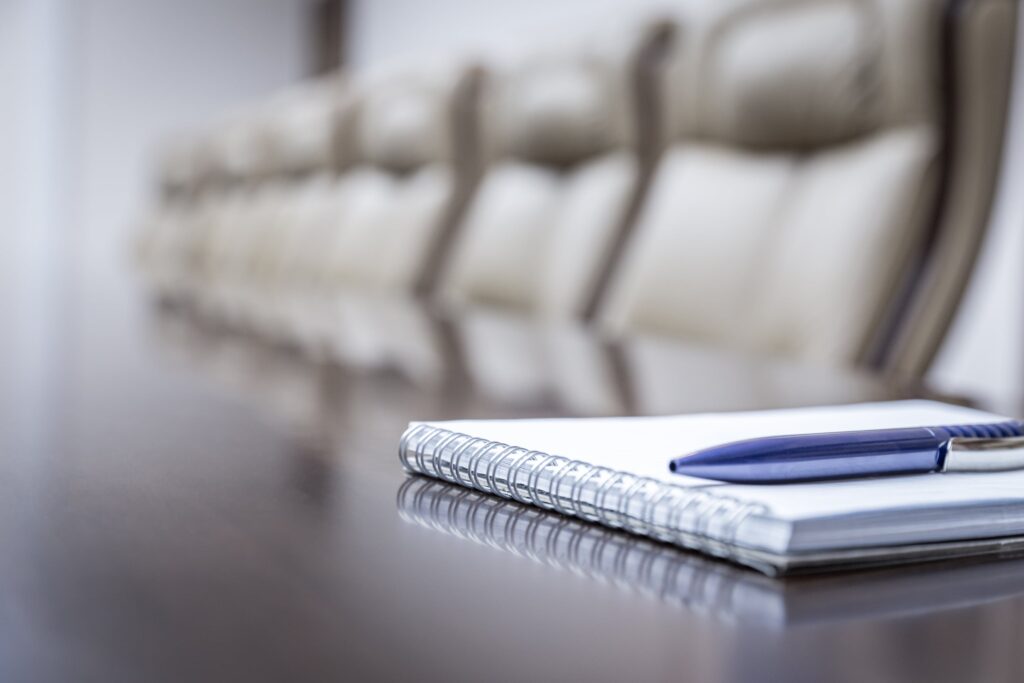 notepad and pen on a desk in a boardroom waiting for the presentation to begin